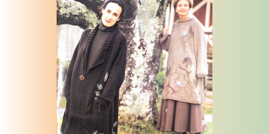 Two models displaying long knit blue fish sweaters one in the forground in brown, one in the background in sand.