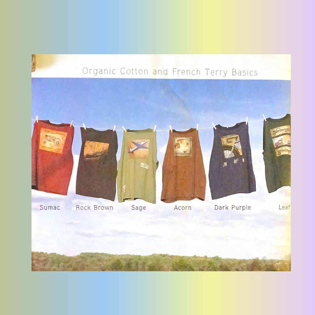 A collection of vintage Men's Blue Fish Clothing t-shirts, and the color pallets with unique themes per piece. The tees are strung on a clothes line in the sky with blue clouds and green tree tops.