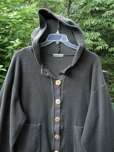 Barclay Celtic Moss Swing Hooded Jacket Unpainted Army Grey Size 2 displayed on a swinger, showcasing its plush texture, cozy hoodie, A-line shape, scooped hemline, oversized buttons, and front drop pockets.