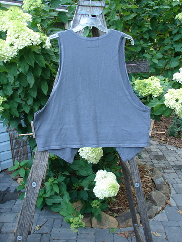 Barclay Calligrapher's Crop Vest Stone Grey Unpainted Size 1 on a wooden rack, showcasing a deep V neckline, single button closure, dramatic front points, and deep arm openings.