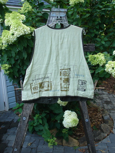 2000 Cross Dye Linen Edge of the World Vest Directional Grid Celery Size 0 displayed on a hanger, featuring rolled piping, looped button closures, handmade glazed ceramic buttons, and a varying hemline with an A-line shape.