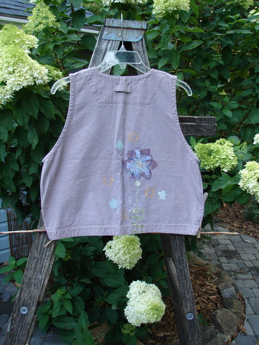 2000 Parachute Cross Stitch Vest Floral Pale Purple Altered Size 0 featuring a deep V neckline, metal button closures, and floral patterns on an outdoor mannequin.