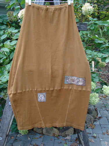Barclay Patched Thermal Parlor Skirt Floral Copper Size 0 displayed on a wooden pole, showcasing a rose pattern and unique stitchery, highlighting its generous cut and bell shape from Bluefishfinder.com.