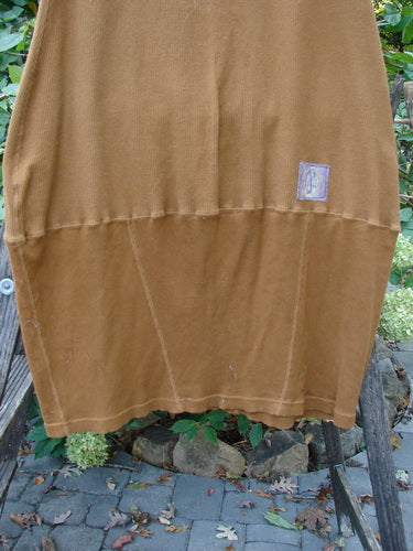 Barclay Patched Thermal Parlor Skirt Floral Copper Size 0 displayed on a wooden stand outdoors, showcasing its vertical and horizontal stitchery and unique reverse bell shape, highlighting its vintage-inspired design.