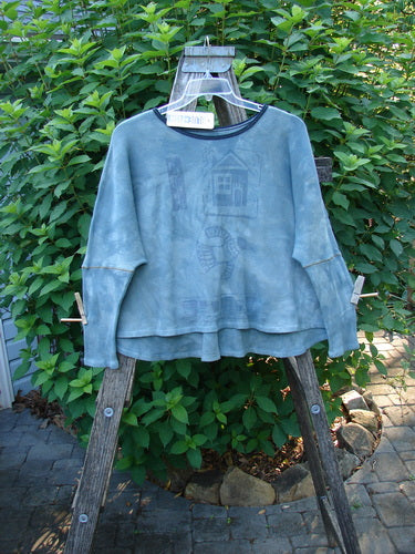 Barclay NWT Thermal Crop Top Love Dove Mottled Top Lake OSFA displayed on a clothes rack, showcasing its rounded neckline, varying hem, A-line flair, and contrasting stitches in a soft waffle texture.