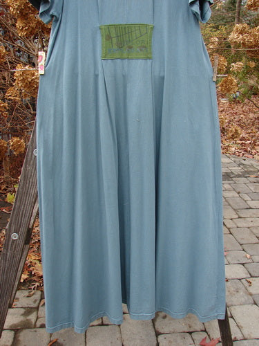 2000 PMU City Side Dress Directional Puddle Size 1 hanging on a clothesline, featuring a V-shaped neckline, three front painted pockets, and a unique rear center patch.