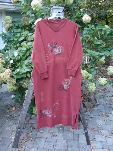 1996 Pastime Dress Abstraction Ember Size 2: A full-length red dress with cartoon-like face motifs, featuring a ribbed V-shaped neckline, long sleeves, vented sides, and deep inseam pockets.