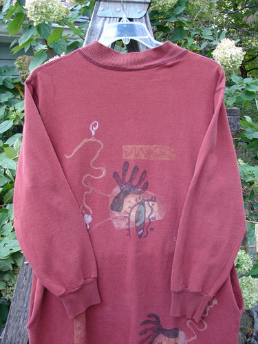 1996 Pastime Dress Abstraction Ember Size 2 displayed on a swing, showcasing its longer length with vented sides, deep side pockets, ribbed V-neckline, and cozy cuffed sleeves.