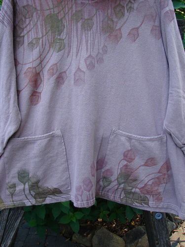 Close-up of the Barclay Cotton Hemp Hooded Folklore Pullover Tiny Floral Mallow OSFA, showcasing its cordless hood, ribbed cuffs, painted floral pockets, and distinctive wide square flared swing design.