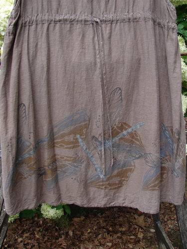 Barclay Hemp Cotton Silk Voile Venetian Pinafore Dragonfly in mocha, size 0, with a softly gathered waist and airy, sheer voile texture. The skirt falls in a loose A-line drape, marked by a delicate blue dragonfly print near the hem.