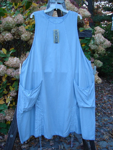 Barclay NWT Twill Joyous Jumper Unpainted Sky Size 2 on a clothesline, showcasing double front pockets, deep arm openings, and a sweeping A-line shape, made from organic cotton twill.