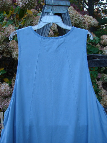 Barclay NWT Twill Joyous Jumper Unpainted Sky Size 2 displayed on an outdoor swing, showcasing deep arm openings, double front pockets, and a sweeping A-line shape.