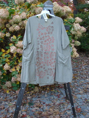 Barclay NWT Batiste Bliss Dress in Fallen Petal theme, displayed on a hanger, featuring a rounded neckline, short sleeves, two exterior pockets, and a drawcord back, perfect for vintage Blue Fish Clothing enthusiasts.