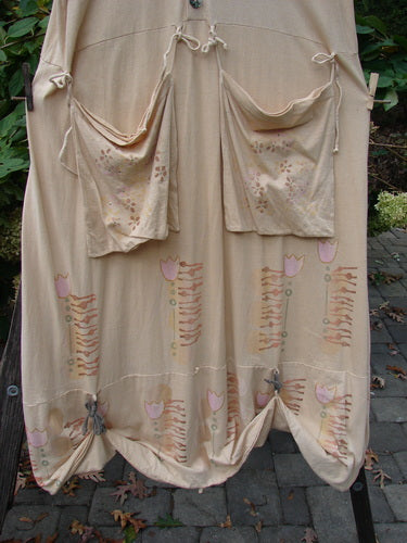 Barclay Salt Water Taffy Jumper Tulip Garden Wheat Size 2 hanging on a clothesline, showcasing its organic cotton fabric, versatile rippie accents, and shell-textured buttons, embodying vintage Blue Fish Clothing's creative style.