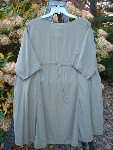 Barclay NWT Batiste Bliss Dress Fallen Petal Dovetail Size 2 displayed on a swinging hanger, showcasing a soft rounded neckline, short sleeves, and two exterior pockets with a drawcord back.