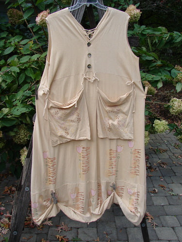 Barclay Salt Water Taffy Jumper Tulip Garden Wheat Size 2 on rack, showcasing organic cotton with shell-textured buttons, tie-on pockets, and curved bodice, reflecting vintage Blue Fish Clothing's creative flair.