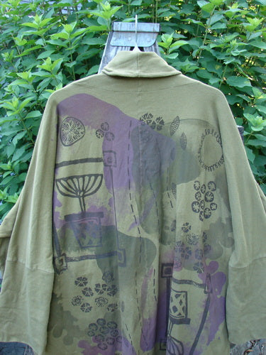 Barclay Reprocessed Golden Hour Deco Jacket Rear Folly Peapod OSFA features a unique design with diagonal raw-topped pockets, a deep V-shaped neckline, and distinctive rear artwork, embodying creative vintage fashion.