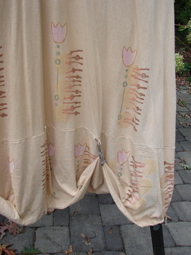 Barclay Salt Water Taffy Jumper Tulip Garden Wheat Size 2 featuring a close-up of the curtain-like organic cotton textile with intricate shell-textured buttons and tie-on pockets, embodying whimsical vintage style.