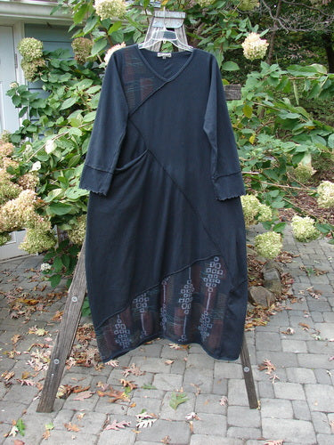 Barclay Diagonal Pocket Dress Stick Stone Black Size 0 displayed on a tree swing, showcasing its extra-long length, wide A-line shape, slight V-neckline, and detailed diagonal seams.