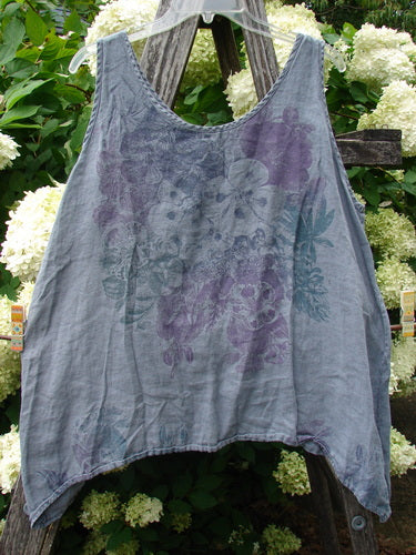 Barclay Linen Altoll Top Pansy Patch in blue dust, size 0, a sleeveless linen top with a soft crinkled texture and faded floral pansy print in muted blue and purple. It drapes loosely on a hanger, with a scooped neckline and gently uneven hem.