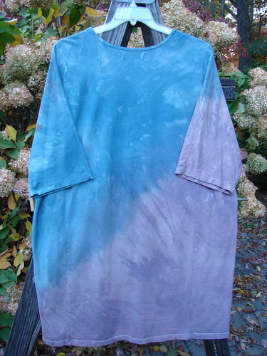 Barclay NWT Tournesol Top Abstract Floral Denim Amethyst OSFA displayed on a clothes rack, showcasing its longer tunic length, drop shoulders, and loose three-quarter sleeves.