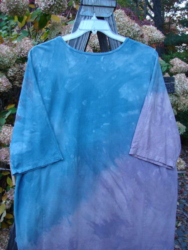 Barclay NWT Tournesol Top Abstract Floral Denim Amethyst OSFA displayed on a hanger, featuring a tunic length, drop shoulders, and a rounded neckline with a varying hemline.