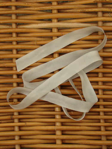 Blue Fish Hand Dyed Silk Ribbon in Moon Dust, 108 x 5/8th, displayed on a wicker basket, showcasing its light, flowing texture.