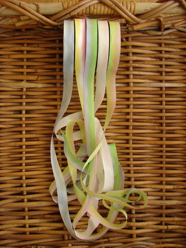 Blue Fish Hand Dyed Silk Ribbon in Peach Blossom, a bunch of colorful ribbons from a wicker basket. Use to run through button holes, loops, or gather for drape and flow.