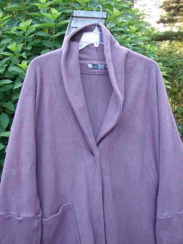 Barclay Patched Celtic Moss Deco Coat, displayed on a swinger, highlights its oversized vintage button, deep V neckline, and unique dolman sleeves, embodying BlueFishFinder's vintage, creative fashion ethos.