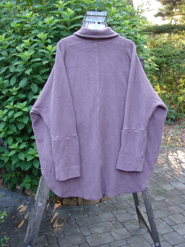 Barclay Patched Celtic Moss Deco Coat Unpainted Aubergine Dust OSFA displayed on a wooden stand, showcasing its oversized vintage button, drop dolman shoulders, and deep V neckline with a stand-up rear collar.