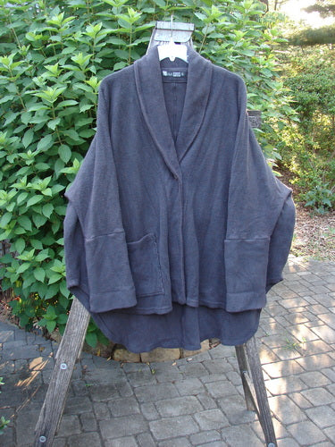 Barclay Patched Celtic Moss Deco Coat Unpainted Stormy Black OSFA displayed on a rack, showcasing its textured cotton fleece, oversized vintage button, deep V neckline, and unique dolman sleeves.