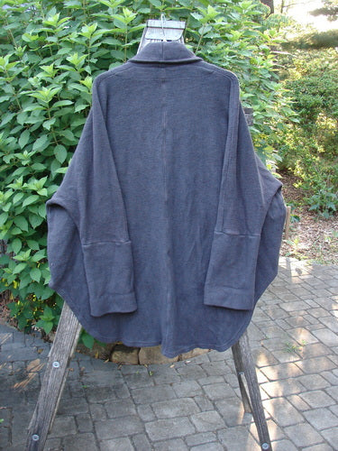 Barclay Patched Celtic Moss Deco Coat Unpainted Stormy Black OSFA displayed on a hanger, showcasing its dense cotton fleece texture, oversized vintage button, dolman shoulders, and distinct flowing shape.