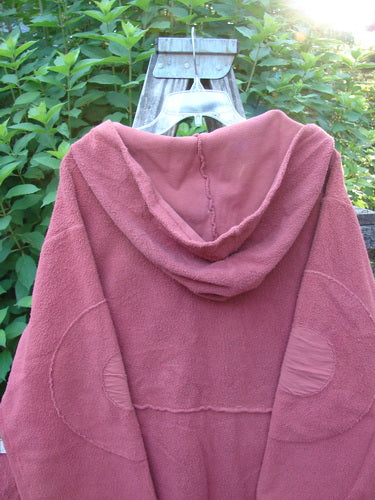 Barclay Celtic Moss Hooded Curve Coat Unpainted Sunset Size 2, featuring a cozy hood, circle sleeve patches, and button line, displayed on a swinger, highlighting its textured feel and sweeping A-line flair.