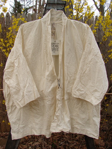 Magnolia Pearl NWT Cotton Poplin Wabi Kimono Natural OSFA displayed outdoors, featuring an open front, square boxy shape, and stand-up rear collar, highlighting its simplicity and versatile layering design.