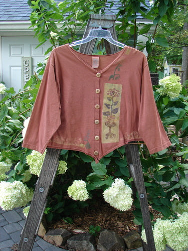 1994 Curve Shirt Potted Sunflower Ochre Size 1 displayed on a hanger, featuring original Blue Fish buttons and a unique hemline with a V-shaped neckline and sunflower-themed paint.