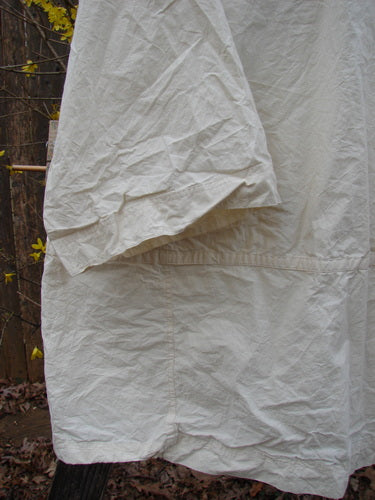 Magnolia Pearl NWT Cotton Poplin Wabi Kimono Natural OSFA displayed on a clothes rack, highlighting its open front and square boxy shape. The kimono's crisp texture is visible.