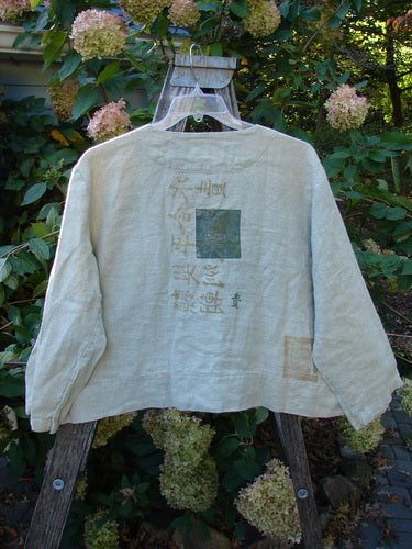 The 1999 PMU Patched Summercloth Hemp Crop Jacket is showcased, featuring drop shoulders, a boxy crop length, and nature-inspired paint, embodying Bluefishfinder.com's vintage, upcycled style.