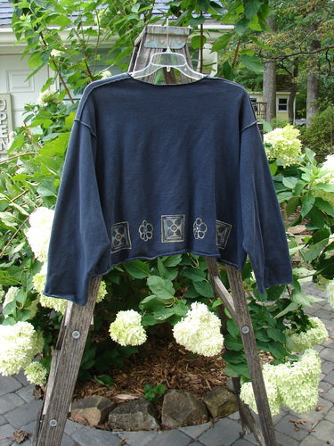 1997 Fleece Long Sleeved Boxy Top with Mosaic Flower detail in Ebony, displayed on a swinger. Features wide, slightly A-lined shape, exterior whip stitching, and drop shoulders.