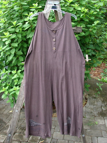 1993 Wide Pant Overall Jumper Star Path Travel Redyed Dark Plum Size 1: A close-up of wide-legged purple overalls with unique front buttons and an empire waist seam, showcasing vintage travel and star path themes.