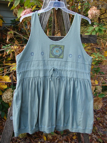 1996 Amusement Jumper Round Wind Trinket Size 1 displayed on a wooden fence, showcasing its double-layered bodice, ribbed hemline, and unique wind-themed design, embodying vintage Blue Fish Clothing style.