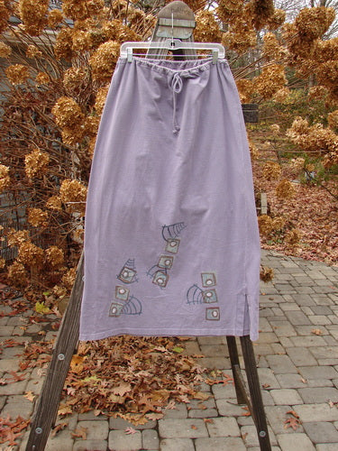 1996 Reprocessed Drawcord Skirt Primitive Mulberry Size 2 on a clothes rack, showcasing full drawcord waist, slightly widening rectangular shape, and side vents, made from heavy weight reprocessed cotton.