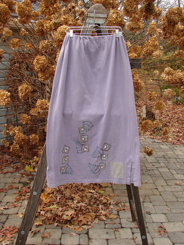 1996 Reprocessed Drawcord Skirt Primitive Mulberry Size 2 on a rack, showcasing a full drawcord waist and 6-inch side vents, made from heavyweight reprocessed cotton with a modern faces design.
