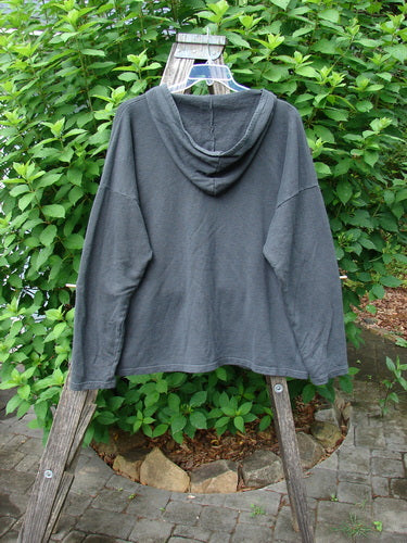 Barclay Cotton Hemp Roo Pocket Hoodie Pullover Metallic Path Black OSFA displayed on a wooden rack, showcasing its cozy fleece texture, generous A-line shape, and distinctive kangaroo pocket.