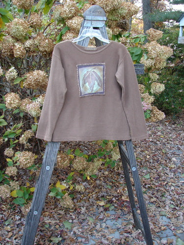 1997 PMU Patched Thermal Long Sleeved Top Leaf Mandorla Size 1: A brown shirt with a leaf patch and whip stitchery border, perfect for layering.