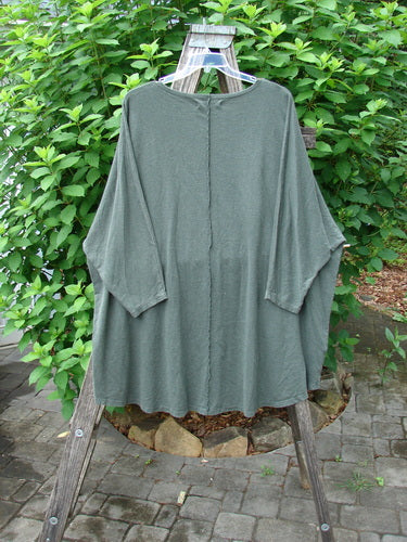 Barclay Cotton Hemp Exterior Stitch Hi Low Tunic Metallic Floral Green Stick OSFA with dolman sleeves, curvy exterior stitchery, and high-low hem, showcased on a clothes rack.