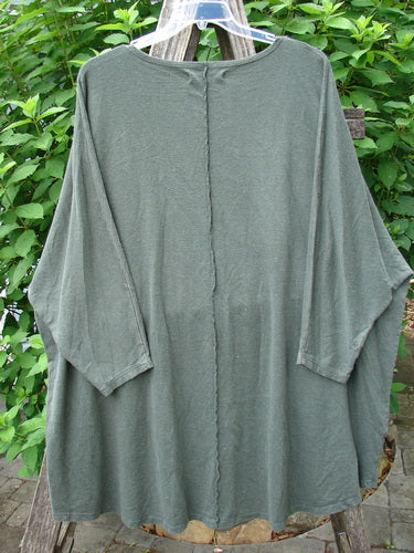 Barclay Cotton Hemp Exterior Stitch Hi Low Tunic Metallic Floral Green Stick OSFA displayed on a rack, showcasing its dolman sleeves, exterior stitching, and high-low hemline with metallic floral accents.