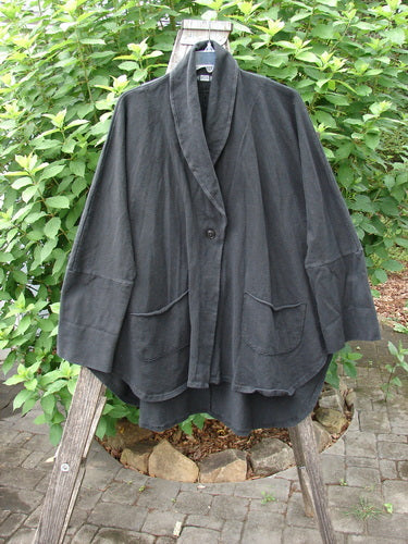 Barclay Reprocessed Golden Hour Deco Jacket Unpainted Black OSFA displayed on a wooden stand, showcasing its thick cotton texture, single button closure, and oversized diagonal pockets.