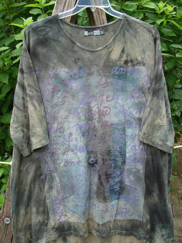 Barclay Tournesol Tunic Wind Script Mottled Green Earth OSFA features purple writing, drop shoulders, three-quarter sleeves, rounded neckline, and varying hemline, perfect for expressing individuality and creativity.