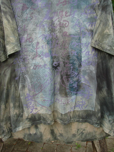 Barclay Tournesol Tunic Wind Script Mottled Green Earth OSFA features a close-up of its medium weight organic cotton fabric, showcasing its unique wind script design, longer back hem, and flattened edges.
