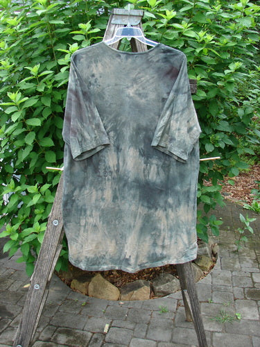 Barclay Tournesol Tunic Wind Script Mottled Green Earth OSFA displayed on a wooden ladder, highlighting its loose three-quarter sleeves, rounded neckline, and varying hemline.